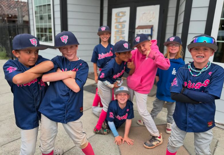 Rivals players in navy jerseys and pink-logo caps posing outside
